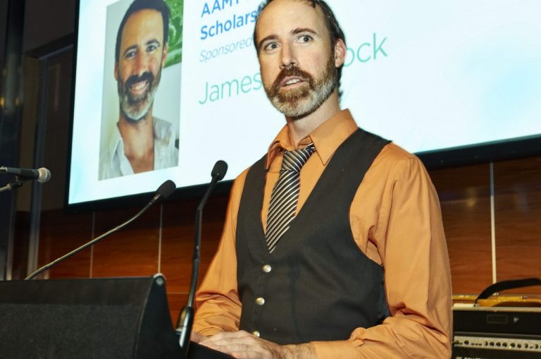 Photo of a remedial massage therapist speaking at a podium.